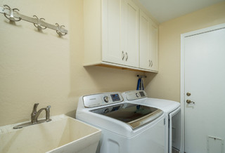 beige walls, high ceilings, laundry room utility sink